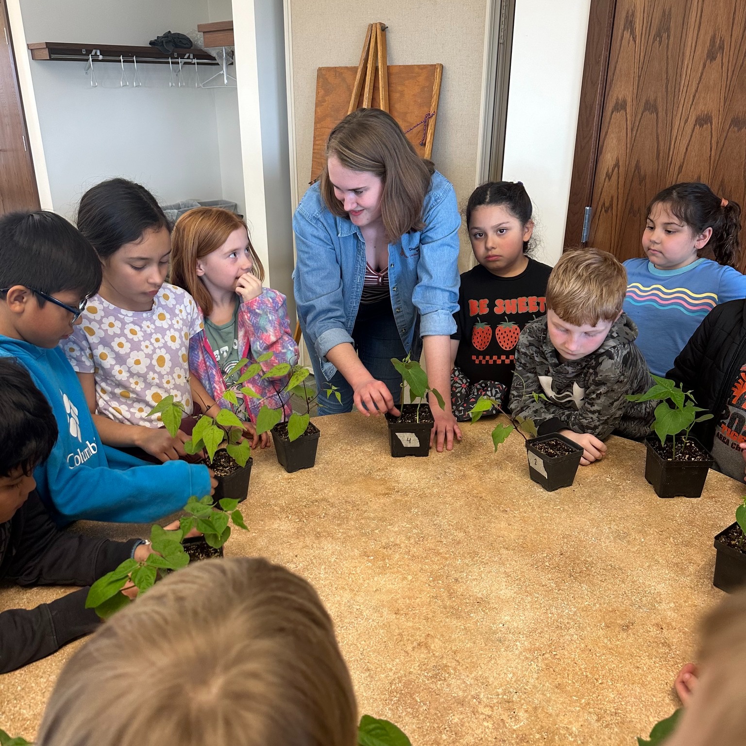 Chloe and several students look at seedlings grown at WCROC.